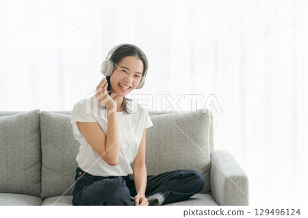 婦女在客廳裡聽音樂 婦女在客廳裡聽音樂 129496124