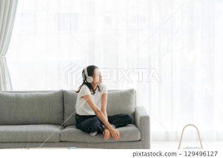 婦女在客廳裡聽音樂 129496127