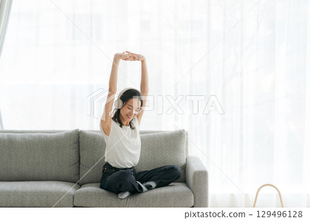 婦女在客廳裡聽音樂 婦女在客廳裡聽音樂 129496128