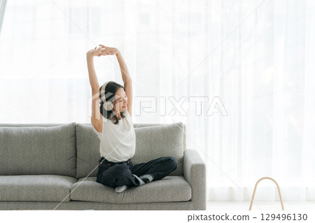 婦女在客廳裡聽音樂 婦女在客廳裡聽音樂 129496130