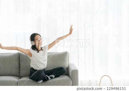 婦女在客廳裡聽音樂 婦女在客廳裡聽音樂 129496131
