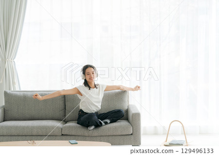 婦女在客廳裡聽音樂 129496133