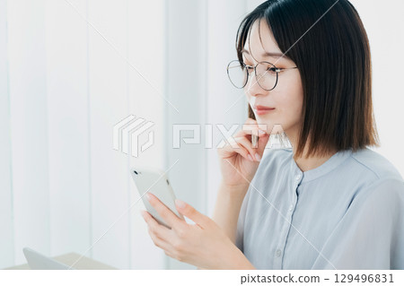 在辦公室看智能手機的女商人 129496831