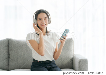 Woman listening to music on smartphone 129496844