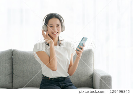 Woman listening to music on smartphone 129496845
