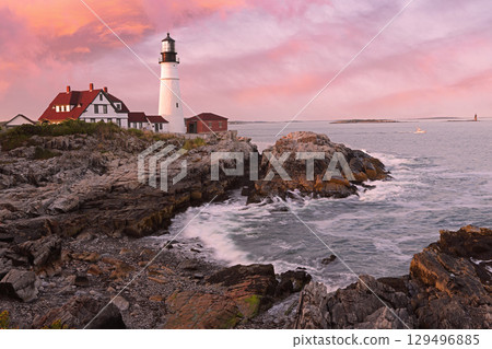 Portland Head Light at sunset surrounded by with dramatic waves and cliffs, Maine, USA 129496885