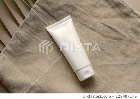 Minimalist White Tube on Soft Fabric Background for Beauty and Skincare Concepts 129497179