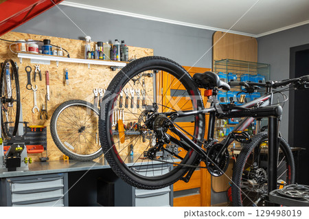 Tool panel with screwdrivers and wrenches, bicycle on stand 129498019