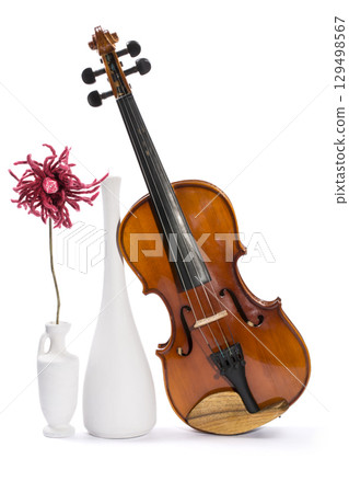 Still-life with a violin, white vases and flower made of wool on a white background 129498567