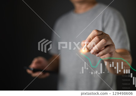 A person interacts with a digital graph, symbolizing investment, finance, or data analysis, while holding a smartphone. A person interacts with a digital graph, symbolizing investment, finance, or data analysis, while holding a smartphone. 129498606