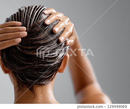 Wet hair treatment in beauty salon with hands massaging scalp and applying shampoo for healthy shiny hair care and relaxation Wet hair treatment in beauty salon with hands massaging scalp and applying shampoo for healthy shiny hair care and relaxation 129499069