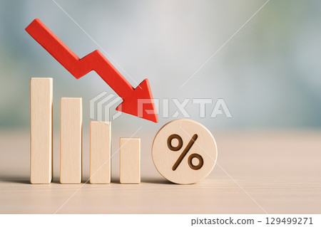 Economic recession and financial crisis are illustrated by stock market decline with red arrow pointing down over wooden blocks and percentage symbol showing falling rates 129499271
