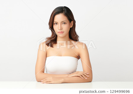 A beautiful young Asian woman with clean, fresh skin against a white background. Skincare, facial treatment, cosmetology, beauty, and spa. An elegant portrait of an Asian woman. 129499696