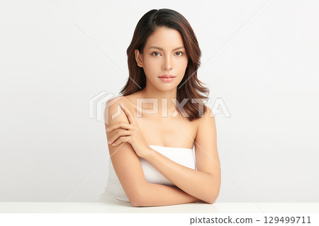 A beautiful young Asian woman with clean, fresh skin against a white background. Skincare, facial treatment, cosmetology, beauty, and spa. An elegant portrait of an Asian woman. 129499711