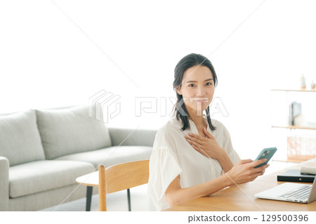 一位女士在客廳使用電腦 一位女士在客廳使用電腦 129500396