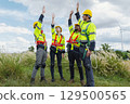 group of construction workers are high fiveing each other in  field 129500565