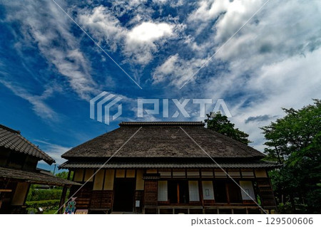 一座古老的農舍在夏日的天空下閃閃發光 129500606