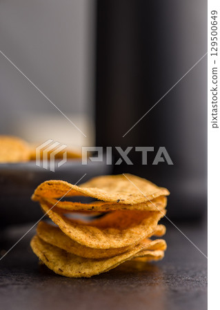Crispy potato chips on black table. Crispy potato chips on black table. 129500649
