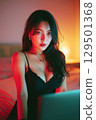 Beautiful sexy young Asian girl webcam model in lingerie chats and sexting online on laptop sitting on bed in bedroom 129501368