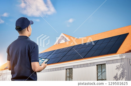Engineer work with solar panels on house roof generate electricity for home use 129501625