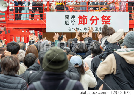 Yokkaichi City, Mie Prefecture - Good men and women reaching out to throw beans during the fox wedding ritual held at Miyamado Shrine every year on Setsubun. 129501674