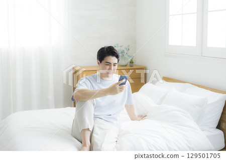 Men watching smartphones in bed 129501705