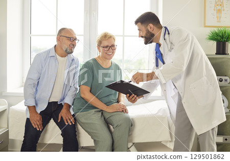 Smiling senior couple consulting with friendly doctor in bright medical office Smiling senior couple consulting with friendly doctor in bright medical office 129501862