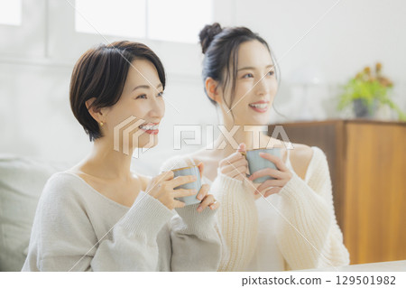 Woman drinking hot coffee in her room 129501982