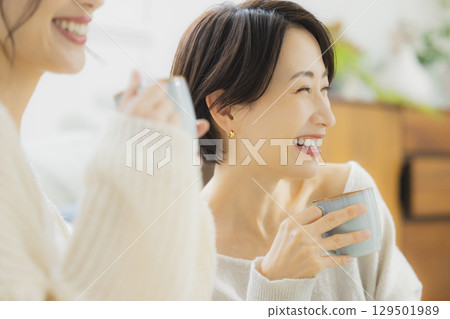 Woman drinking hot coffee in her room 129501989