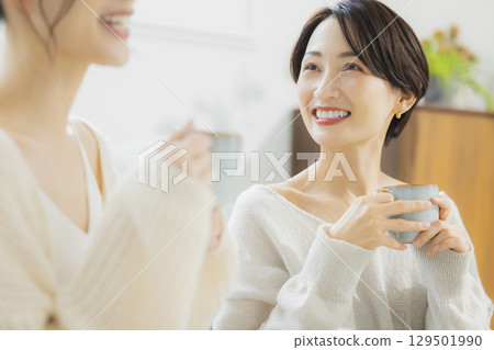 Woman drinking hot coffee in her room 129501990