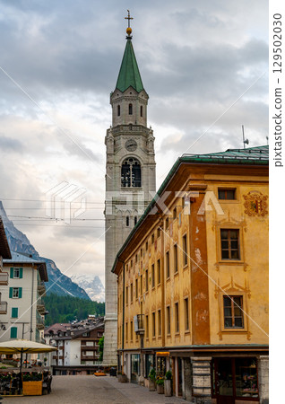 A view of the iconic church tower in the heart of Cortina d'Ampezzo. The architectural beauty of the tower stands tall against the backdrop of the surrounding Alpine scenery A view of the iconic church tower in the heart of Cortina d'Ampezzo. The architectural beauty of the tower stands tall against the backdrop of the surrounding Alpine scenery 129502030