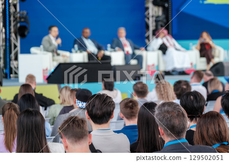 Audience listens to panel speakers at professional conference event Audience listens to panel speakers at professional conference event 129502051