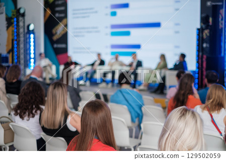 Business conference with professionals discussing ideas on stage 129502059