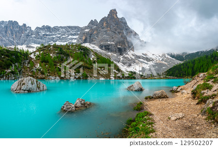 Panoramic view of Lago Sorapis in the Dolomites (Dolomiti, Dolomiten), Italy. The turquoise lake is surrounded by towering cliffs and mountains, a popular spot for hikers and nature lovers Panoramic view of Lago Sorapis in the Dolomites (Dolomiti, Dolomiten), Italy. The turquoise lake is surrounded by towering cliffs and mountains, a popular spot for hikers and nature lovers 129502207