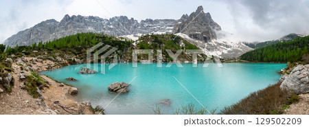 Panoramic view of Lago Sorapis in the Dolomites (Dolomiti, Dolomiten), Italy. The turquoise lake is surrounded by towering cliffs and mountains, a popular spot for hikers and nature lovers Panoramic view of Lago Sorapis in the Dolomites (Dolomiti, Dolomiten), Italy. The turquoise lake is surrounded by towering cliffs and mountains, a popular spot for hikers and nature lovers 129502209