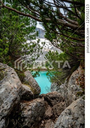 Panoramic view of Lago Sorapis in the Dolomites (Dolomiti, Dolomiten), Italy. The turquoise lake is surrounded by towering cliffs and mountains, a popular spot for hikers and nature lovers Panoramic view of Lago Sorapis in the Dolomites (Dolomiti, Dolomiten), Italy. The turquoise lake is surrounded by towering cliffs and mountains, a popular spot for hikers and nature lovers 129502213
