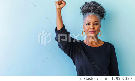 Black mature woman with raised fist of empowerment, strength and women solidarity, International Womens Day, Black History Month concept 129502350