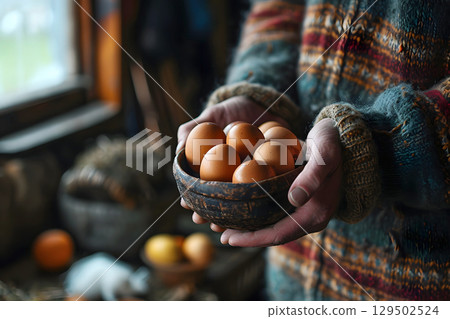 chicken eggs in a basket in the hands of a farmer. farming and grocery business 129502524