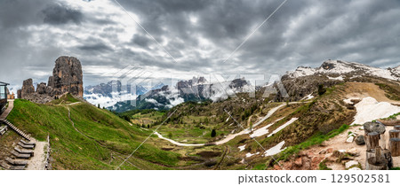 Mountain peaks around Cinque Torri in the Dolomites (Dolomiti, Dolomiten), Italy. Majestic summits partially covered in mist and clouds, with lush forests in the valleys below 129502581