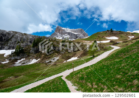 Mountain peaks around Cinque Torri in the Dolomites (Dolomiti, Dolomiten), Italy. Majestic summits partially covered in mist and clouds, with lush forests in the valleys below 129502601