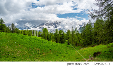Mountain peaks around Cinque Torri in the Dolomites (Dolomiti, Dolomiten), Italy. Majestic summits partially covered in mist and clouds, with lush forests in the valleys below Mountain peaks around Cinque Torri in the Dolomites (Dolomiti, Dolomiten), Italy. Majestic summits partially covered in mist and clouds, with lush forests in the valleys below 129502604