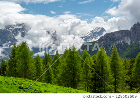 Mountain peaks around Cinque Torri in the Dolomites (Dolomiti, Dolomiten), Italy. Majestic summits partially covered in mist and clouds, with lush forests in the valleys below Mountain peaks around Cinque Torri in the Dolomites (Dolomiti, Dolomiten), Italy. Majestic summits partially covered in mist and clouds, with lush forests in the valleys below 129502609