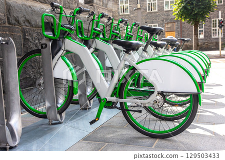 Exploring Norway's bike-sharing system with sleek green and white bicycles lined up 129503433