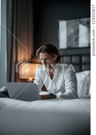business traveler working on laptop in hotel room business traveler working on laptop in hotel room 129503817