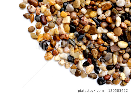 Small colorful pebbles on a white background. 129505432