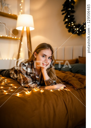 Cozy relaxation with warm lighting and Christmas decor in the bedroom 129506485