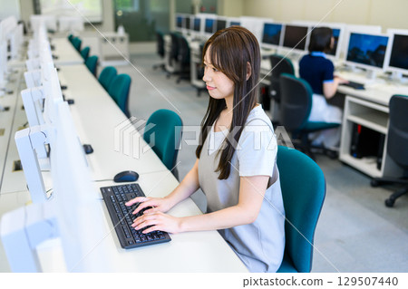Female student concentrating on computer work Female student concentrating on computer work 129507440