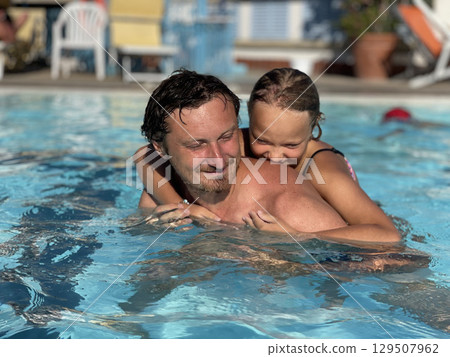 Father and Daughter Enjoying a Fun Pool Time 129507962