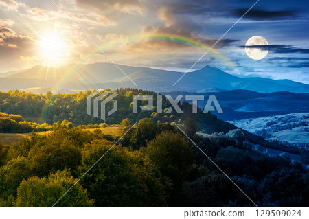 countryside landscape on autumn equinox. day and night time change concept. village in the valley and rural fields on the forested hills. mountain ridge with high peak under sky with sun and moon countryside landscape on autumn equinox. day and night time change concept. village in the valley and rural fields on the forested hills. mountain ridge with high peak under sky with sun and moon 129509024
