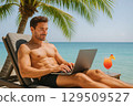 A handsome muscular man relaxes under palm trees with laptop. 129509527